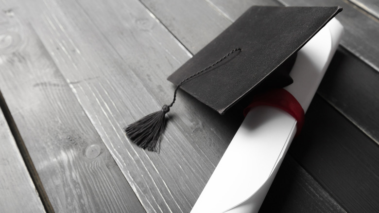 Graduation cap and rolled-up diploma