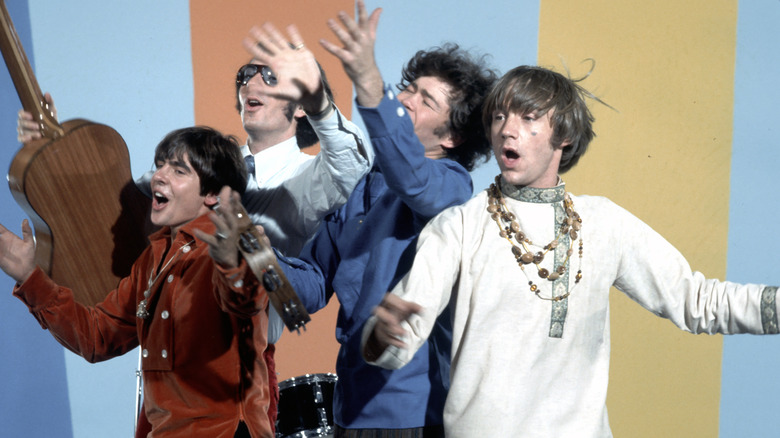 The Monkees arms open, mouths open