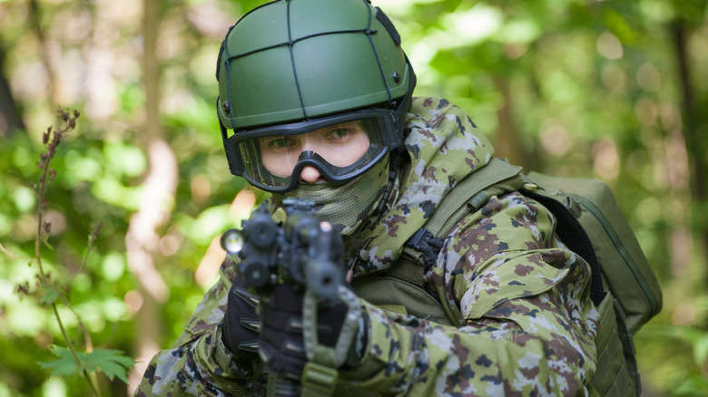 Man in camo pointing gun