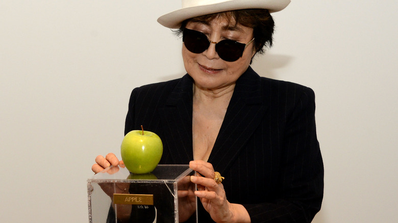 Yoko Ono with an apple on plinth