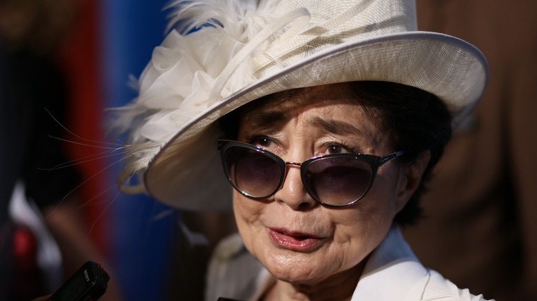Yoko Ono white hat mouth open