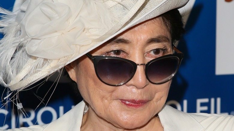 Yoko Ono in white hat and sunglasses