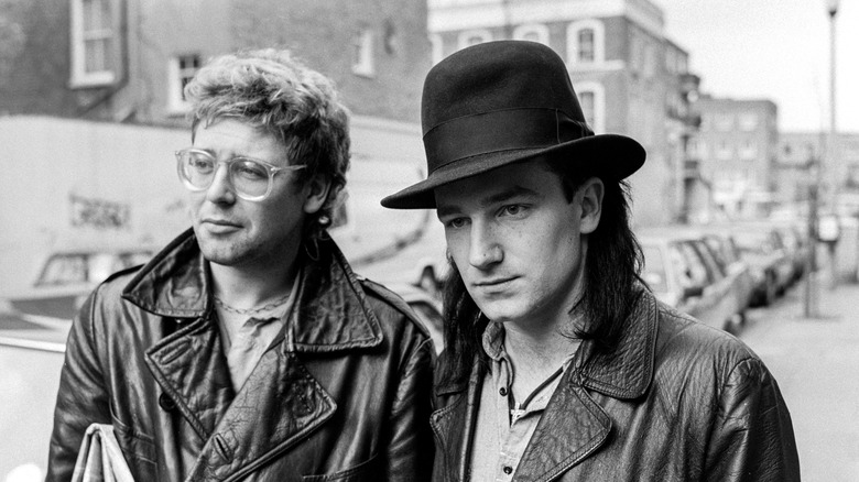 Bono in a hat on the street with another man
