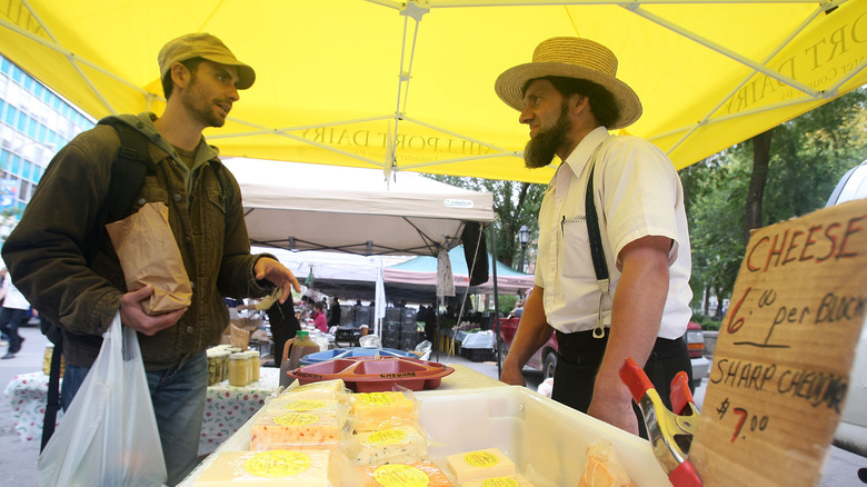 Amish man selling cheese at market