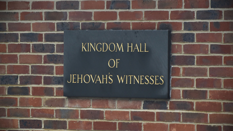 Jehovah's Witness Kingdom Hall sign on brick wall
