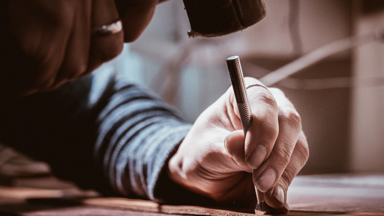 Saddler working with a hammer