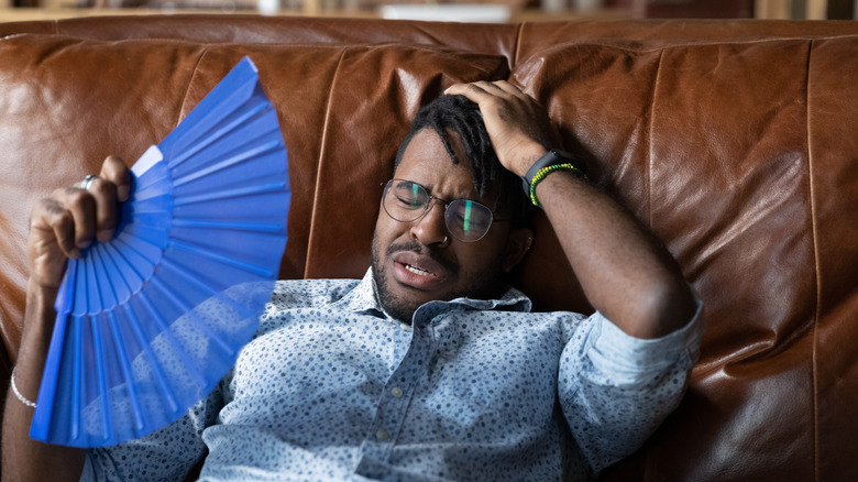 person on couch holding fan