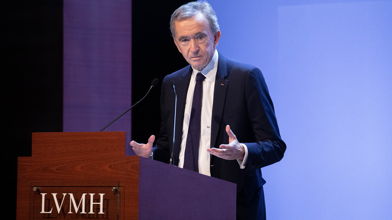 Bernard Arnault behind LVMH podium hands open