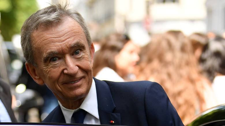 Bernard Arnault smiling getting into a car