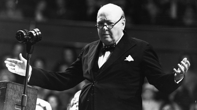 Winston Churchill standing giving speech arms spread wide