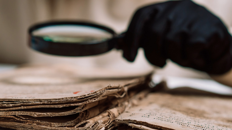 Magnifying glass over ancient documents