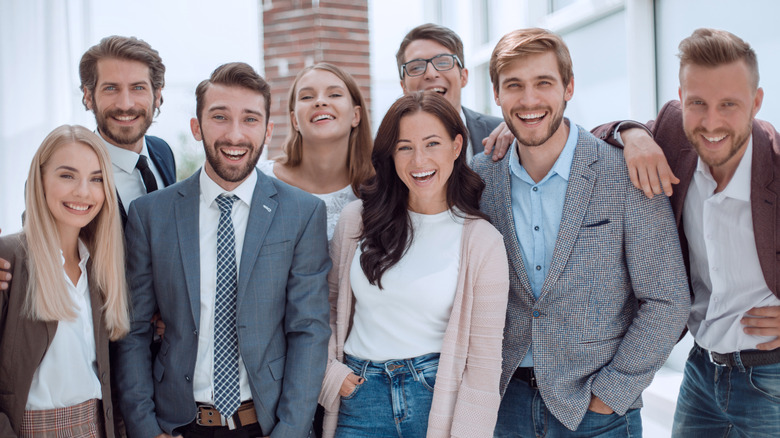 crowd of people standing side by side smiling