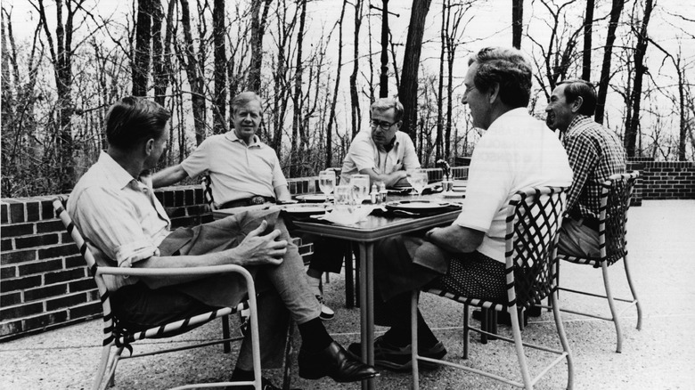 Jimmy Carter with Zbigniew Brzezinski outside at a table