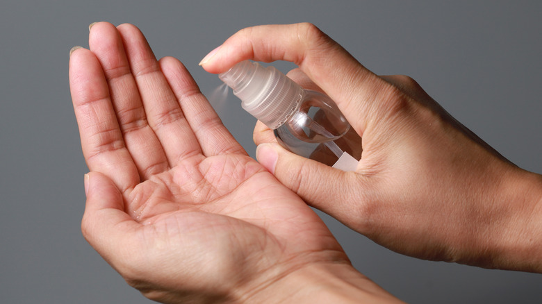 woman cleansing hands with sanitizer