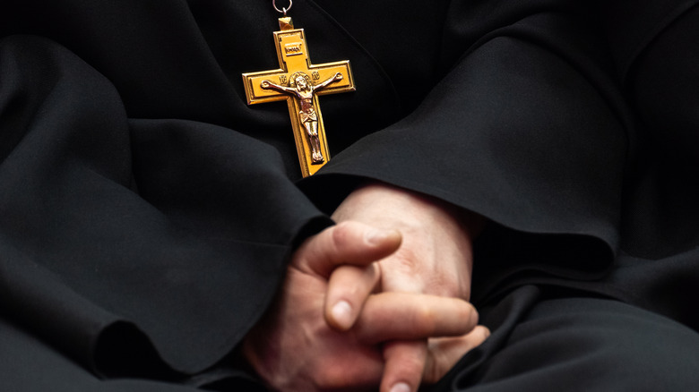 Gold crucifix on man wearing black robe