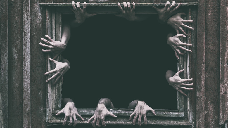 Hands reaching out from creepy window