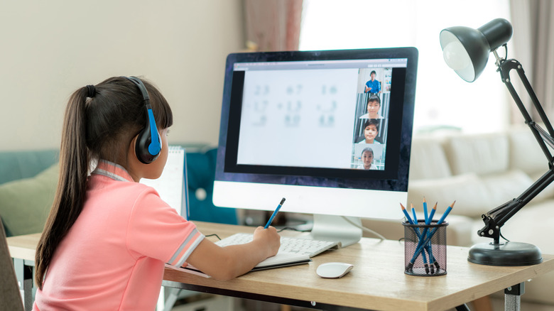 A young girl with headphones at a computer