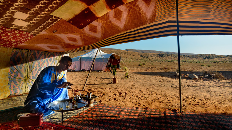 Berber man making tea in a tent in the Sahara