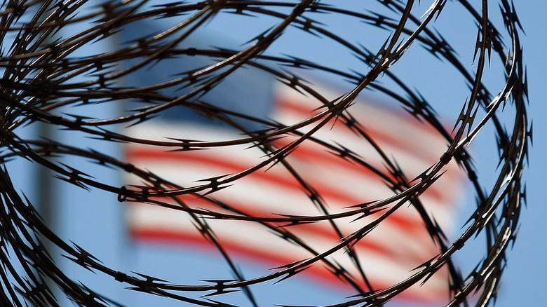 American flag through razor wire