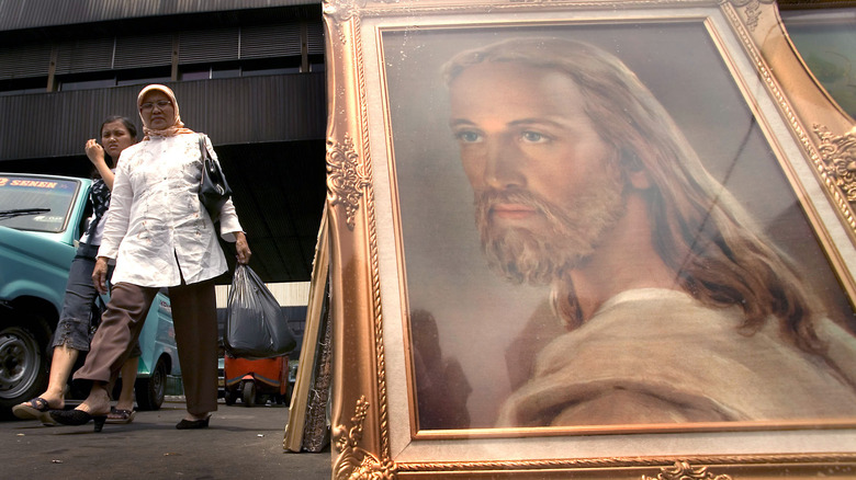 Muslim women in Jakarta walking by Jesus portrait