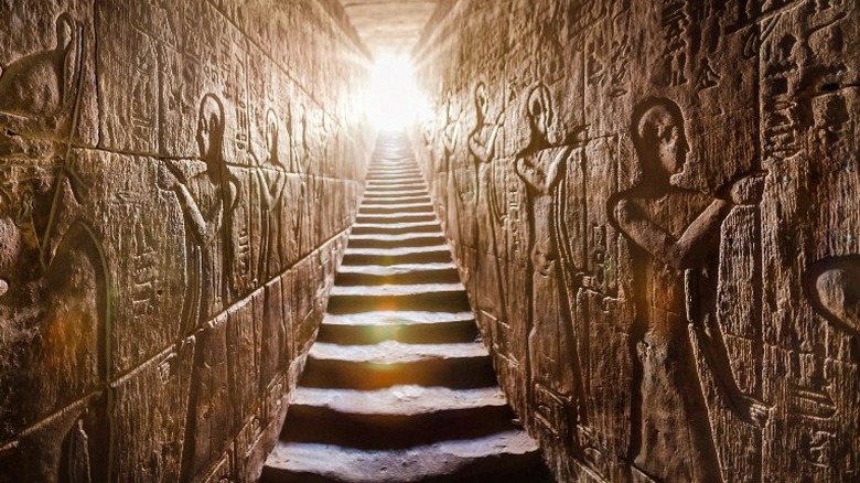 Ancient Egyptian passageway with steps and carvings on the wall