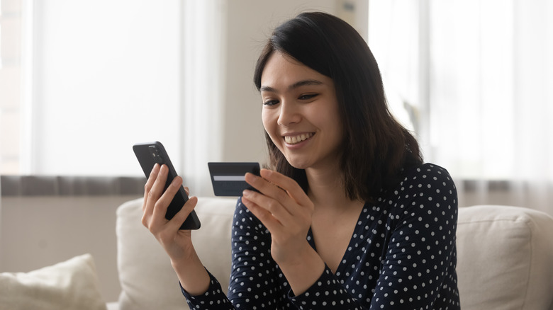 woman holding her phone and credit card