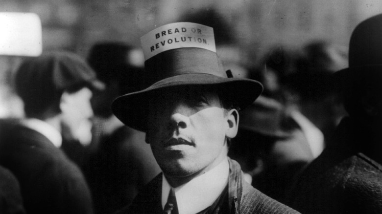 Man with IWW hat card saying Bread or Revolution
