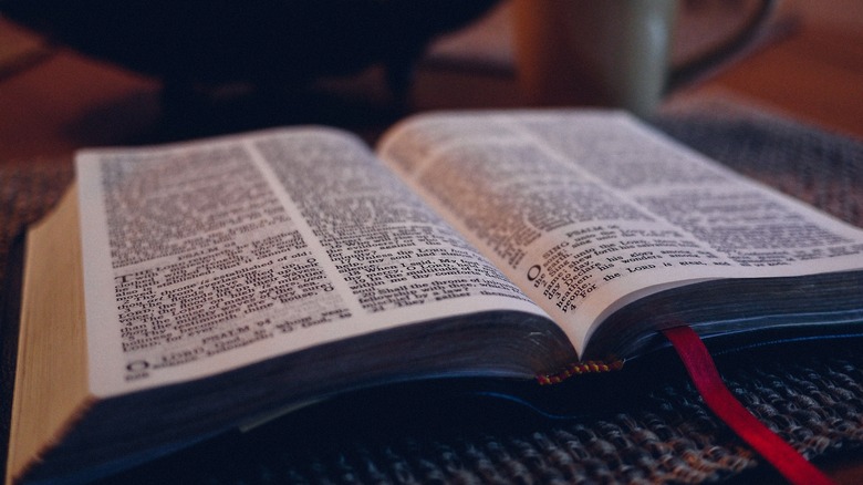 Bible open on table with red ribbon bookmark