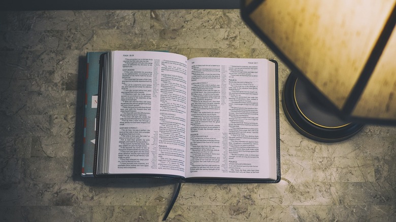 Bible open on table with lamp