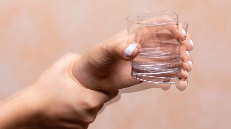 hand holding glass of water