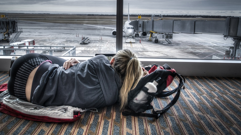 Woman lying down airport terminal