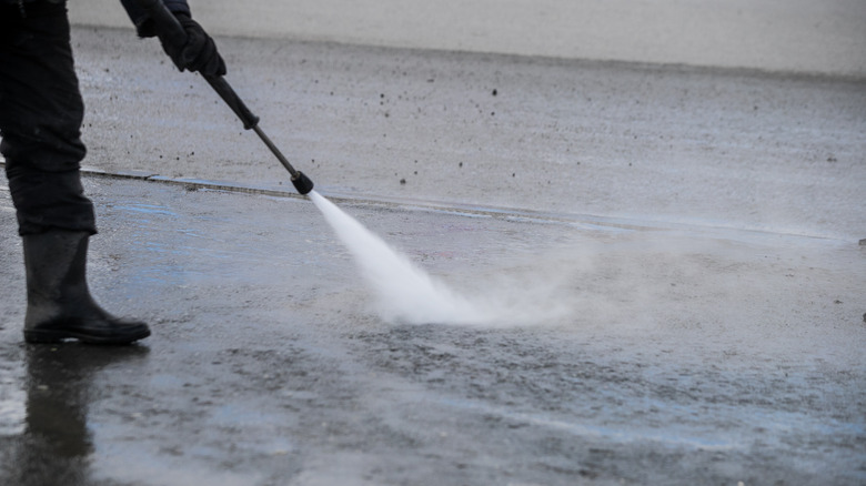 Person power washing a street