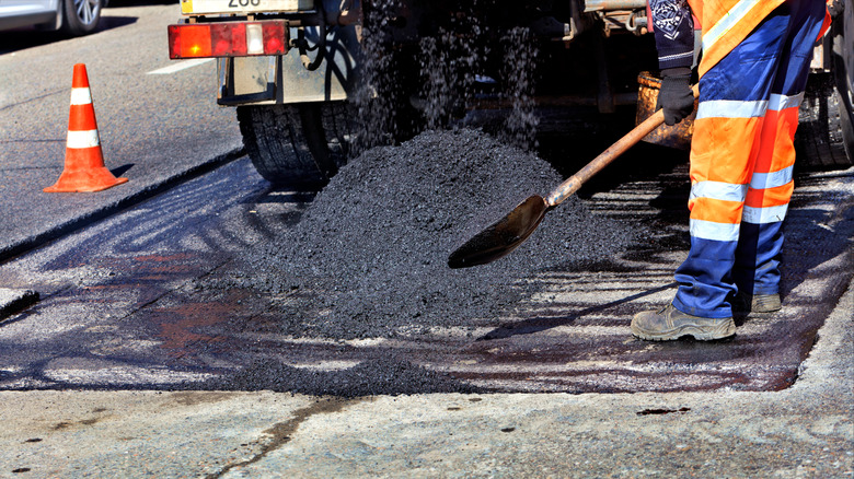 person and truck pouring asphalt