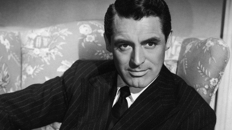 Cary Grant, seated and posing