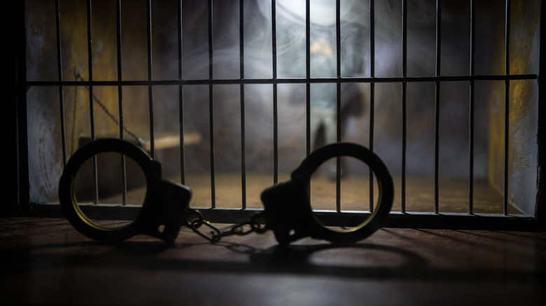 Handcuffs in front of jail bars