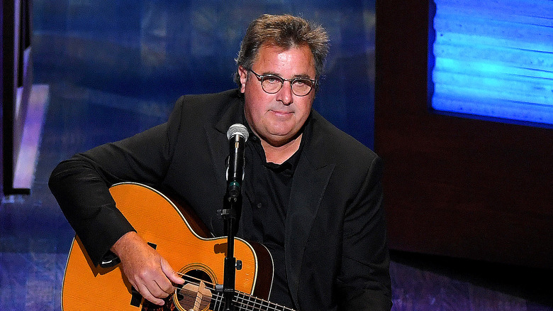 Vince Gill with guitar at mic