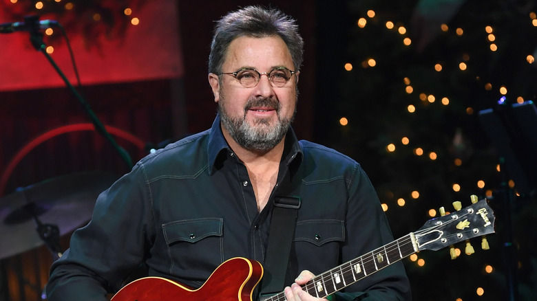 Vince Gill holding red guitar