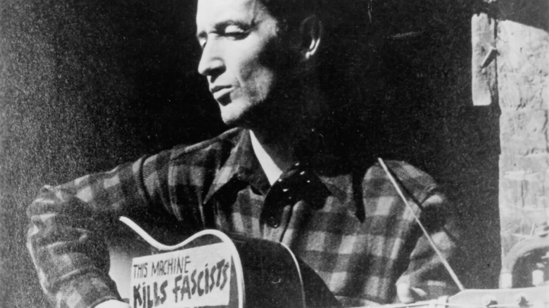 Woody Guthrie with guitar