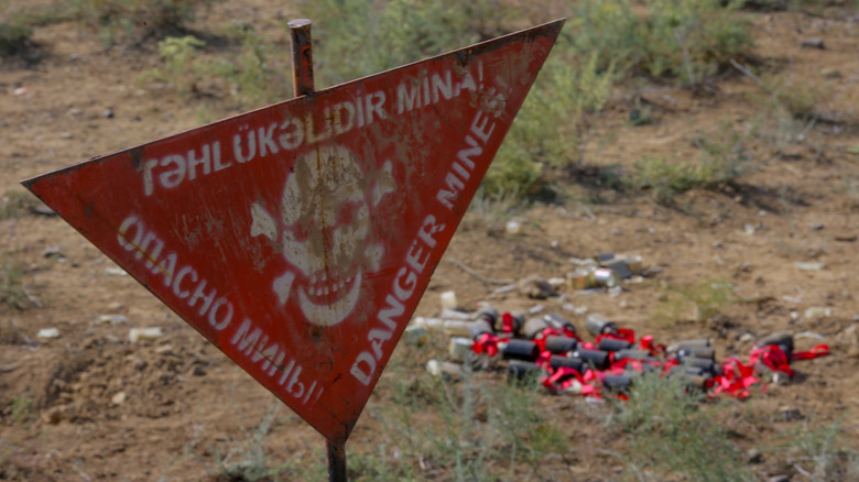 Cluster munitions next to danger sign