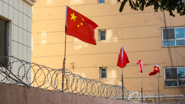 Chinese flags on a barbed wire fence