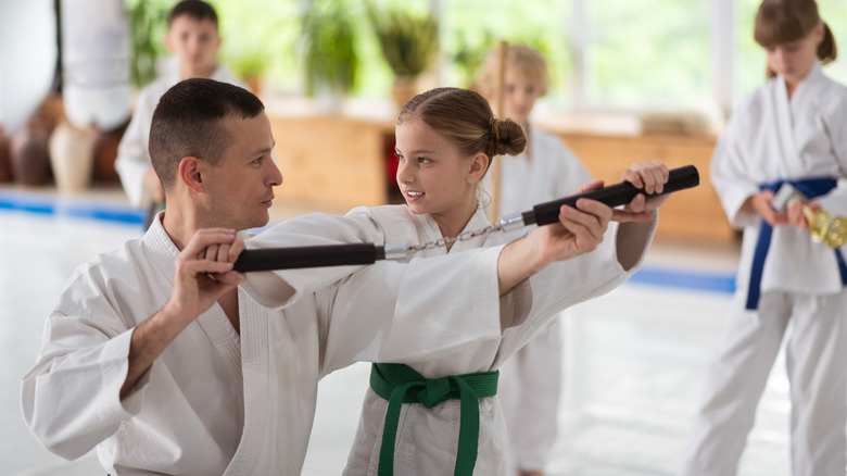 A child learning to use nunchucks