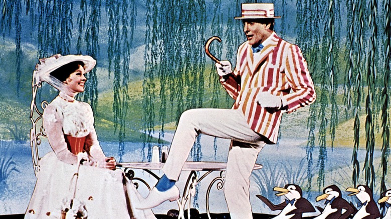 Julie Andrews, seated, while Dick Van Dyke dances