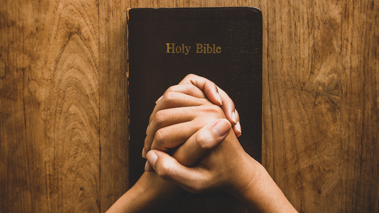 Pair of hands folded on Bible