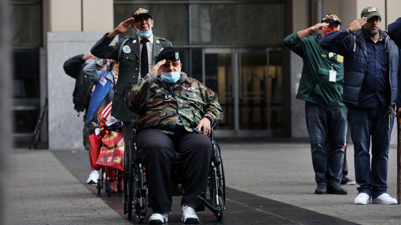 Veterans saluting from sidewalk