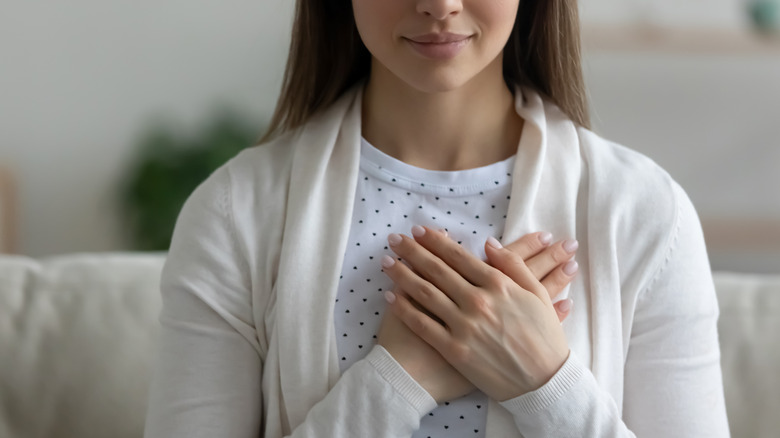 woman with hands over heart