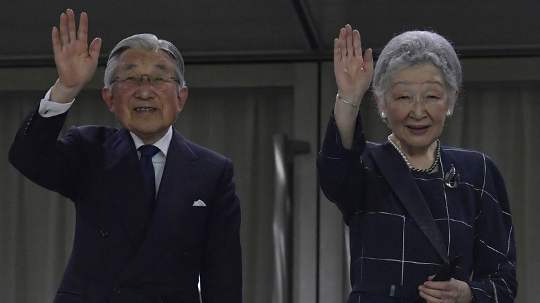 Akihito and Michiko wave to a crowd