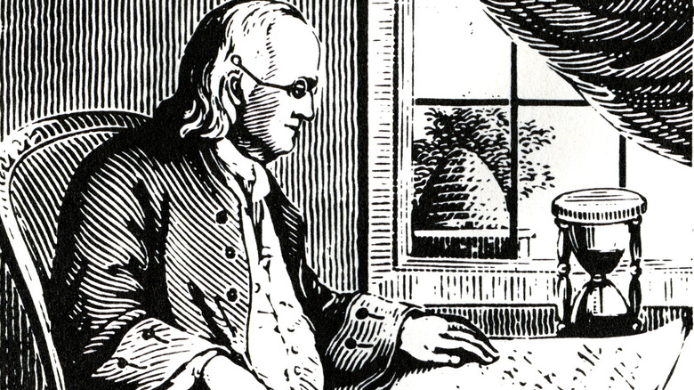 Benjamin Franklin sitting at desk writing