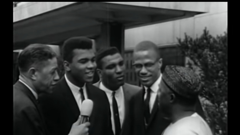 Cassius and Malcolm greeting Nigerian diplomat