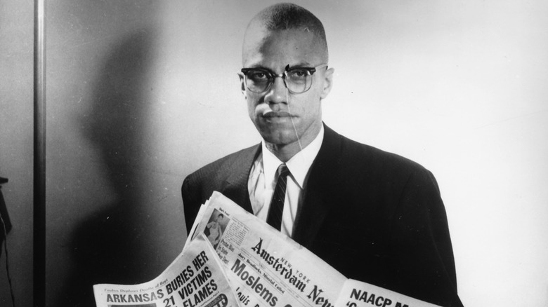 Malcolm X reading papers 