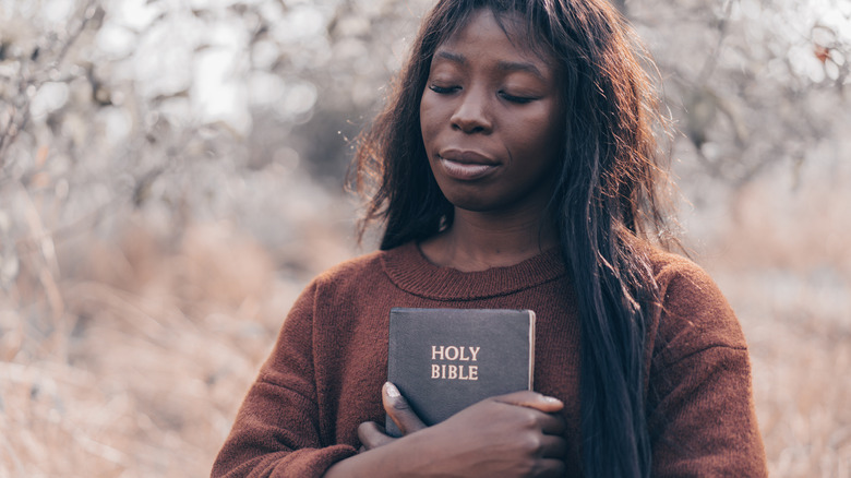 Christian afro girl holds bible in her hands